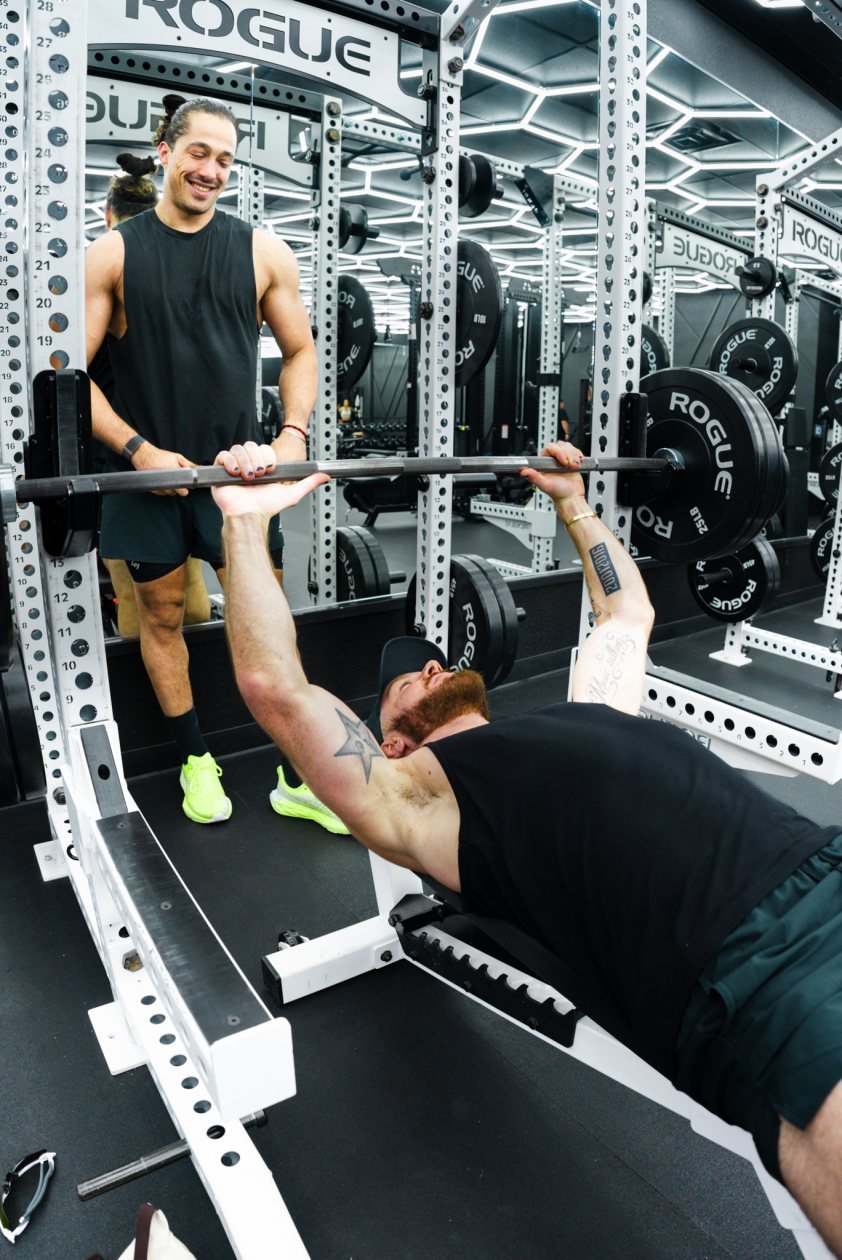 Moe coaching a client through a bench press set